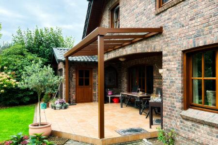 Kleiner Überdachung einer seitlichen Terrasse in Holzdekor passend zum Landhausstil der Fenster und Terrassentüre